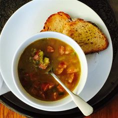 a bowl of soup with bread on the side