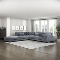 a living room with hardwood floors and gray furniture