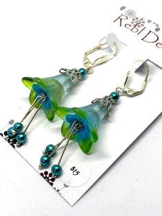 The earrings are made from beautiful hand coloured flower beads. Finished with Swarovski crystals .. Lovely for a bridesmaid, daughter or even just to spoil yourself or someone special. The flowers have been hand coloured by me in my studio. Details of earrings: Size: 7cm top to bottom Colors: Blue Material : Crystals Acrylic flowers Hook Type: Leverback I endeavour to never duplicate any piece. They may be similar but always unique Bead Trees, Trumpet Flower, Shrinky Dink, Resin Jewellery, Pink And Blue Flowers, Acrylic Flowers, Butterfly Hair, Flower Beads, Gorgeous Earrings