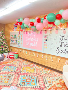 a decorated christmas tree in the corner of a room with balloons and decorations on the wall