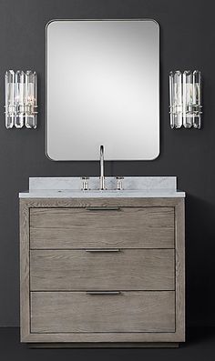 a bathroom vanity with a large mirror above it and lights on the wall next to it