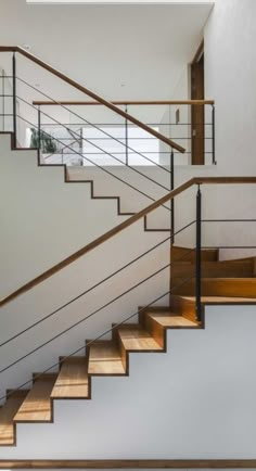 an open staircase with wooden handrails and white walls