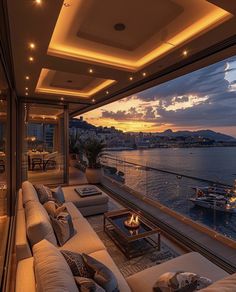 a living room filled with lots of furniture next to a large window overlooking the water