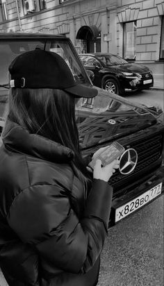 a woman standing next to a parked car