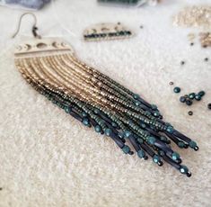 a pair of earrings with beads and chains