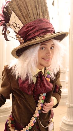 a woman wearing a top hat with feathers and beads on her head is posing for the camera