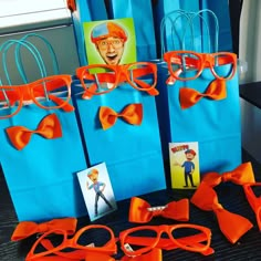 orange bow ties and glasses are on display in front of blue bags with an image of a man's face