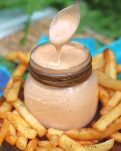 a spoon is sticking out of a jar filled with french fries