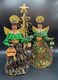 two christmas figurines are standing next to each other in front of a tree