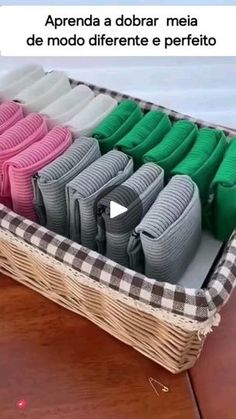 a basket filled with lots of different colored sweaters on top of a wooden table