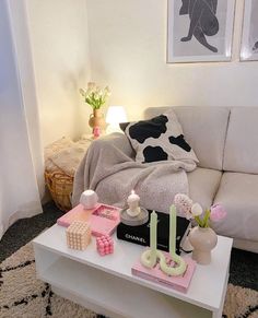 a living room filled with furniture and decor on top of a white coffee table in front of a window