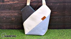 a blue and white bag sitting on top of a green grass covered field next to a wooden wall