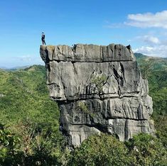 a man standing on top of a large rock