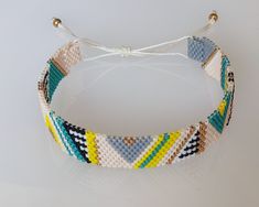 a close up of a bracelet on a white surface with beads and string attached to it