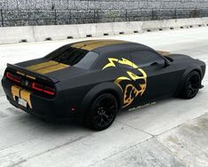 a black sports car with gold stripes on it