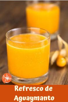 two glasses filled with orange juice on top of a wooden table