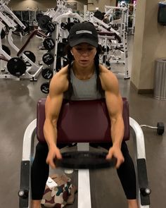 a man sitting on top of a bench in a gym