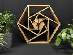 a wooden clock sitting next to some potted plants