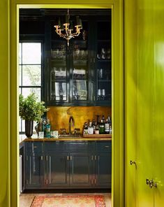 an open door leading into a kitchen with green walls and cabinetry in the background