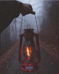 a person holding a red lantern in their hand