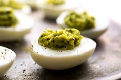 several deviled eggs with pesto on them