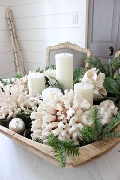 a tray filled with candles and white flowers on top of a table next to a mirror