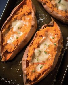 baked sweet potatoes with cheese and chives on a baking sheet, ready to be eaten