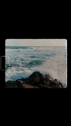 an ocean scene with waves crashing on the rocks