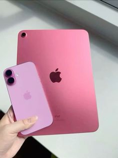 someone holding two different colored iphones in their hands, one is pink and the other is purple