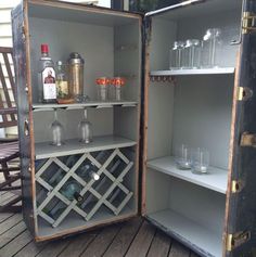 an open cabinet filled with bottles and glasses