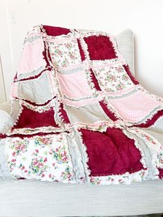 a blanket that is sitting on top of a couch next to a pillow in the shape of a quilt