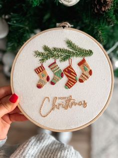 a hand embroidered christmas ornament hanging from a tree