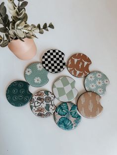 a bunch of buttons sitting on top of a table next to a potted plant