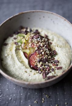 a white bowl filled with hummus and other food items on top of a table