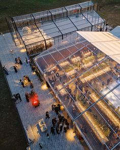 an aerial view of a glass building with people walking around it