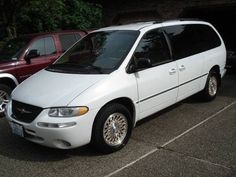 a white van parked in a parking lot next to other cars