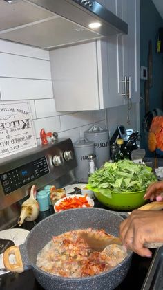 a person is cooking food in a large pan on the stove top, with other ingredients nearby