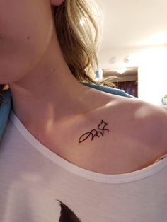 a woman with a small tattoo on her chest that has three stars in the middle