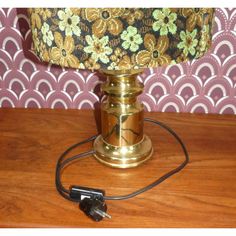 a lamp that is sitting on top of a wooden table next to a wallpaper