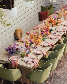 a long table is set with plates and place settings for an elegant dinner party setting