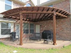 a covered patio with chairs and grill on it