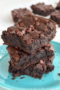 two chocolate brownies stacked on top of each other with one bite taken out of it