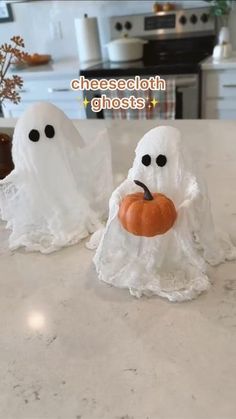 two white ghost figurines sitting on top of a counter