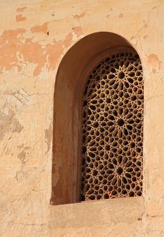 a close up of a window on a wall with a bird sitting on the window sill