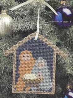 a cross stitch ornament hanging from a christmas tree