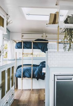 bunk beds in a small room with white walls and wood flooring on the side