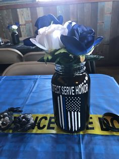 a blue table cloth with an american flag painted on it and flowers in a mason jar