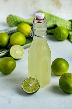 a bottle of limeade next to some limes