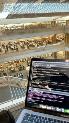 an open laptop computer sitting on top of a desk in front of a large building