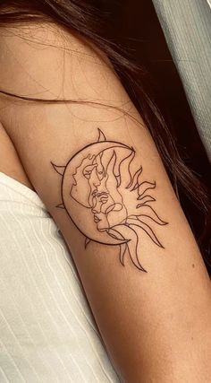 a woman's arm with a sun and half moon tattoo on her left shoulder